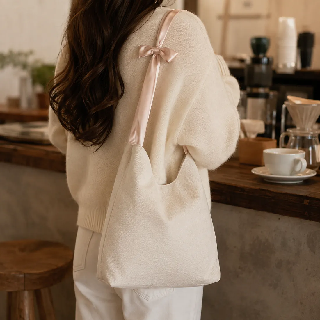 Cream bow-handle canvas bag at a cafe / 咖啡馆场景中的米白色蝴蝶结手柄帆布包