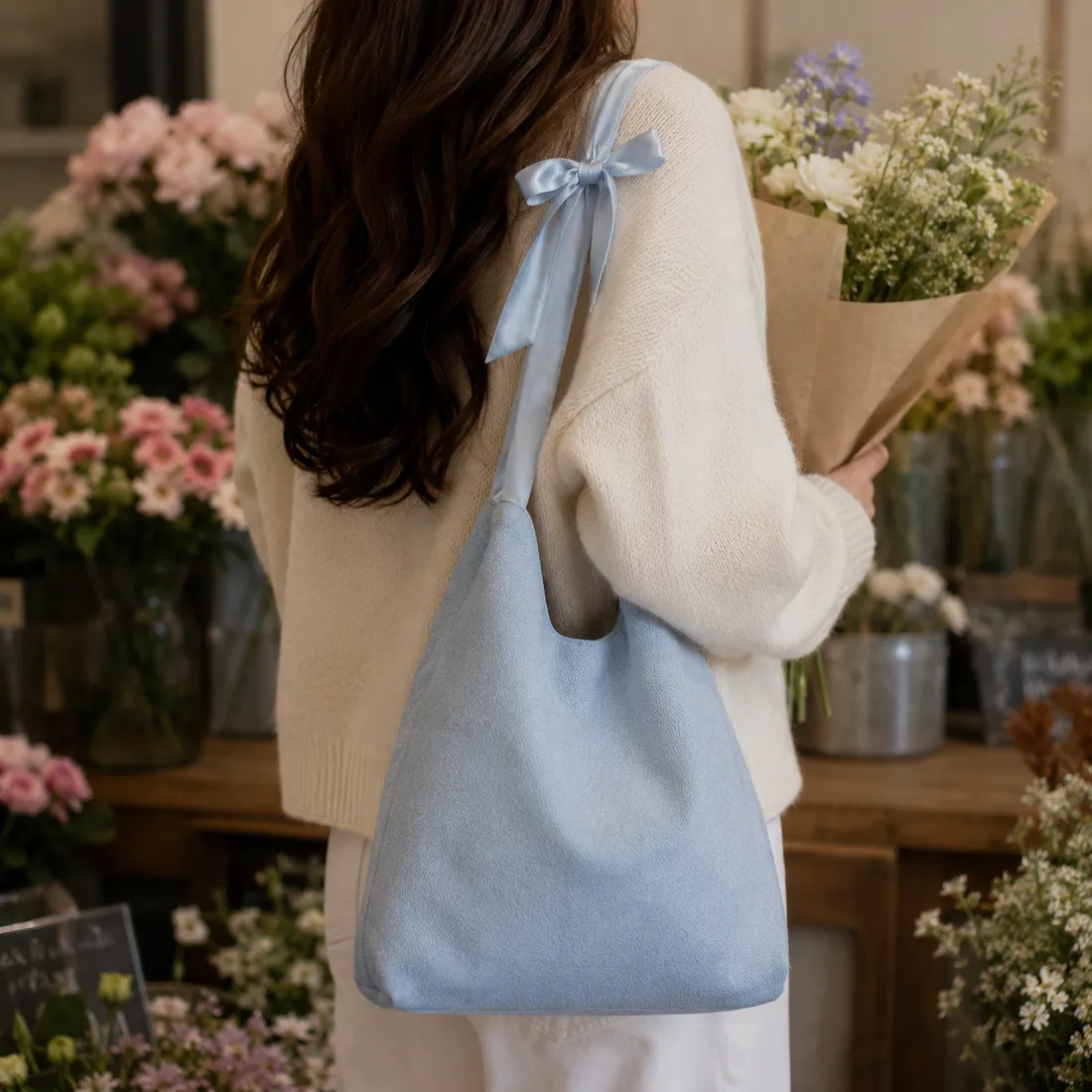 Light blue bow-handle canvas bag at a flower market / 花市场景中的浅蓝色蝴蝶结手柄帆布包