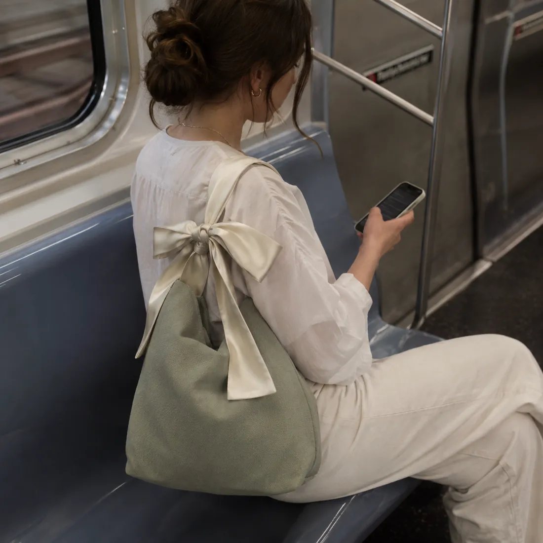 Sage bow-handle canvas bag on a train / 列车场景中的鼠尾草绿色蝴蝶结手柄帆布包
