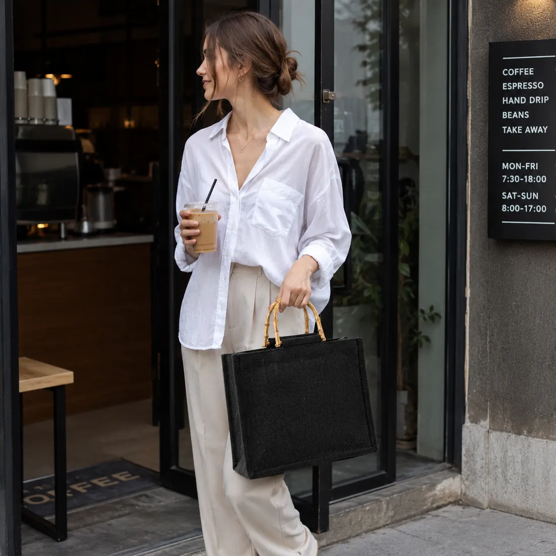 Black faux bamboo-handle jute tote at a cafe entrance / 咖啡馆门口场景中的黑色仿竹手柄黄麻托特包